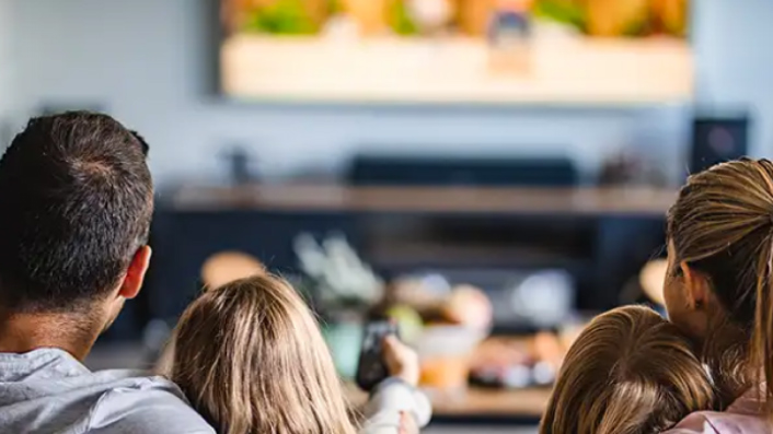 A family is watching video streaming content on TV in the living room