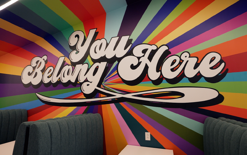 A colorful mural is painted on a company room wall.