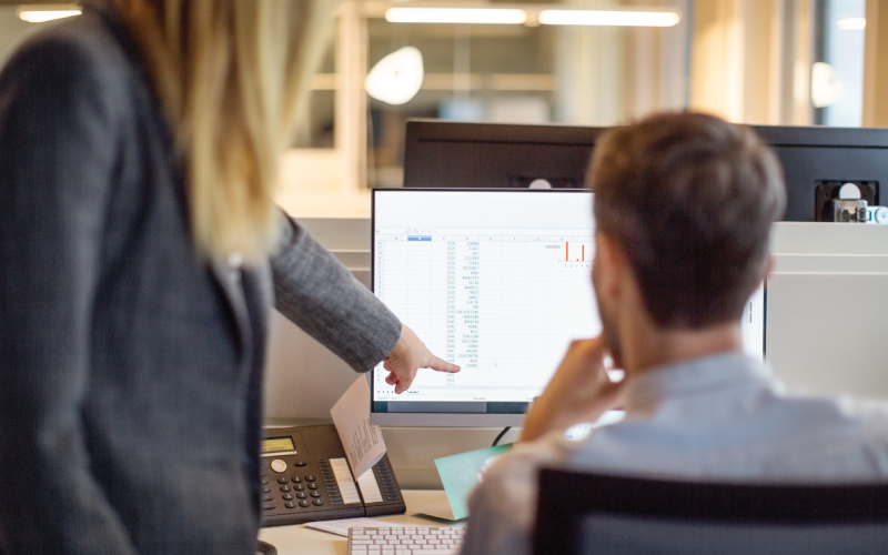 A female employee is providing feedback to a male employee on his project work