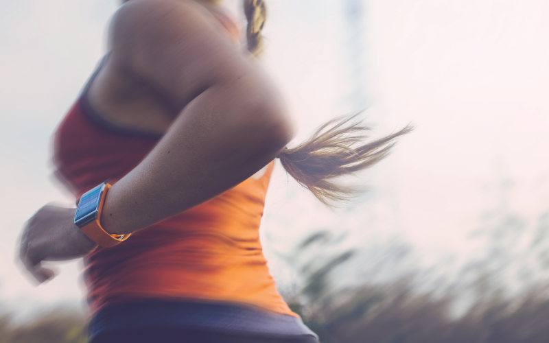 A female is running and is tracking health data on a smartwatch