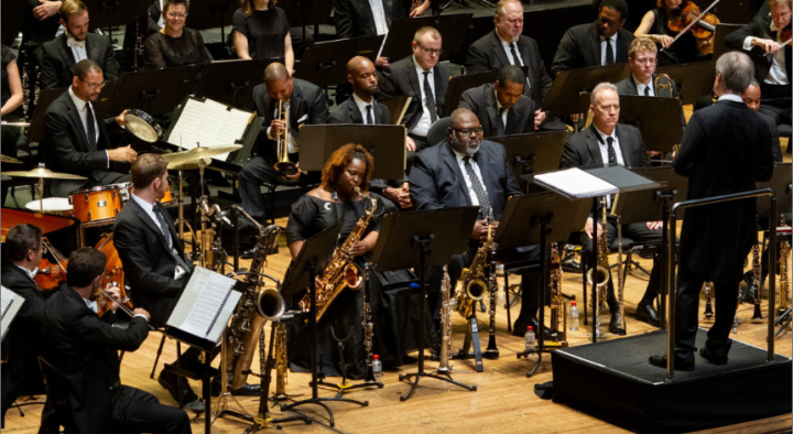 An orchestra is performing on stage in a concert.